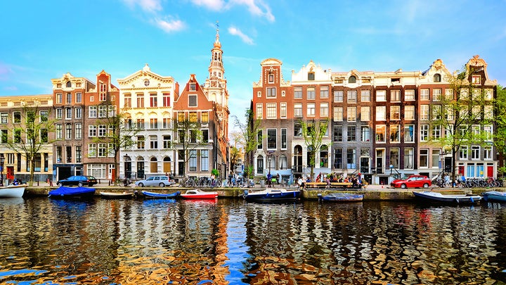 Boats reflected in an Amsterdam canal, The Netherlands.