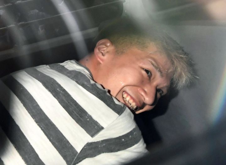 Mass killing suspect Satoshi Uematsu is seen inside a police car as he is taken to prosecutors