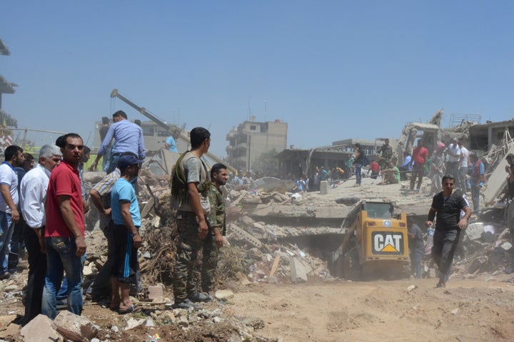 People look for survivors under debris at a damaged site after the attack.