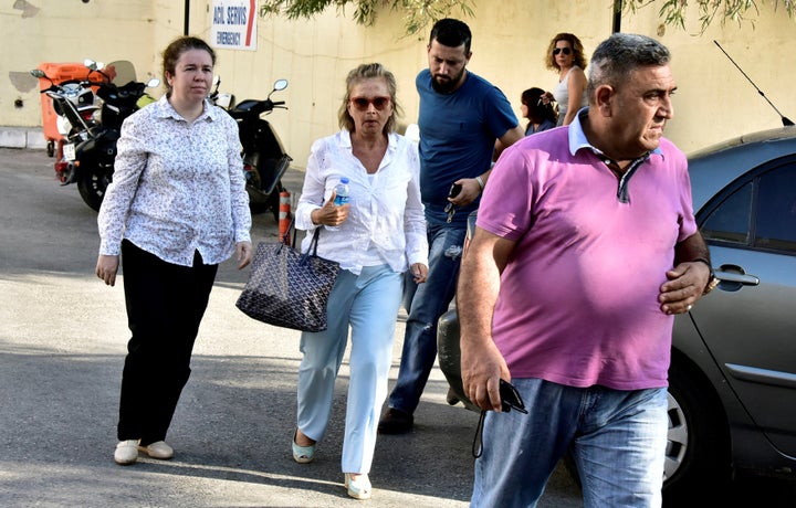 Turkish journalist Nazli Ilicak (C), a well-known commentator and former parliamentarian, is escorted by a police officer (R) and her relatives (L and rear) after being detained in Bodrum, Turkey on Tuesday.