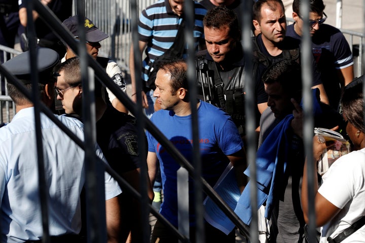 One of the Turkish soldiers who fled to Greece (C) is escorted by special police forces after the postponement of their interviews for asylum request at the Asylum Service in Athens on Wednesday.