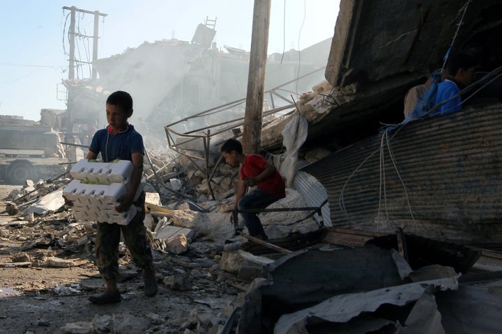 Boys salvage goods from a site hit by airstrikes in the rebel held town of Atareb in Aleppo province on Monday.