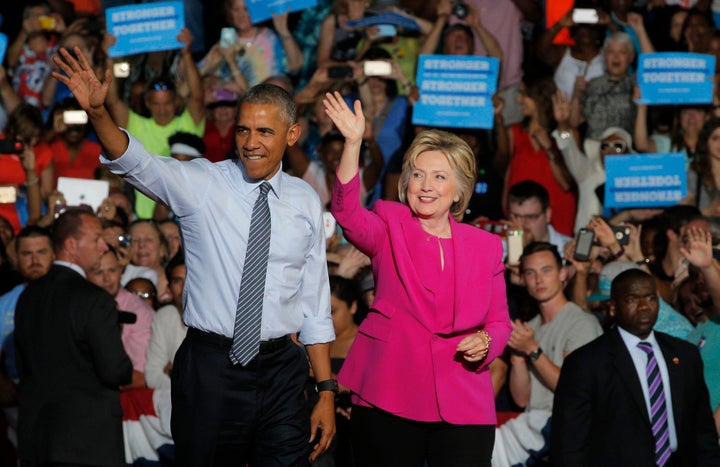U.S. President Barack Obama waves with Democratic U.S. presidential candidate Hillary Clinton during a Clinton campaign event