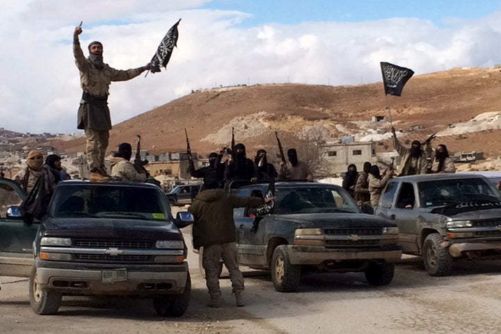 Al Qaeda-linked Nusra Front fighters carry weapons on the back of pick-up trucks in Arsal, eastern Bekaa Valley, Lebanon, December 1, 2015