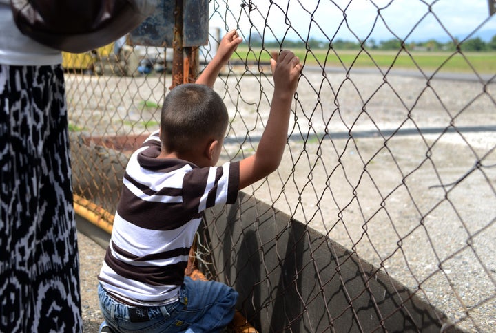 A boy watches as a plane carrying deportees from the United States lands in San Pedro Sula, Honduras. Clinton's comment about sending unaccompanied Central American minors back tarnished her reputation for some immigrant rights activists.