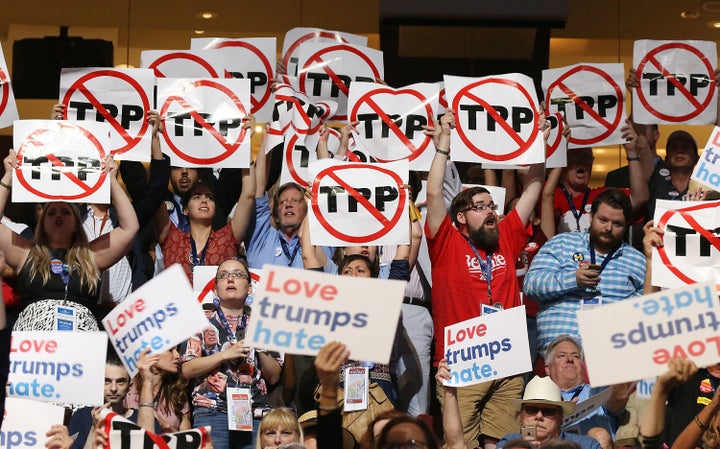 Delegates show their opposition to the Trans-Pacific Partnership agreement on the first day of the Democratic National C