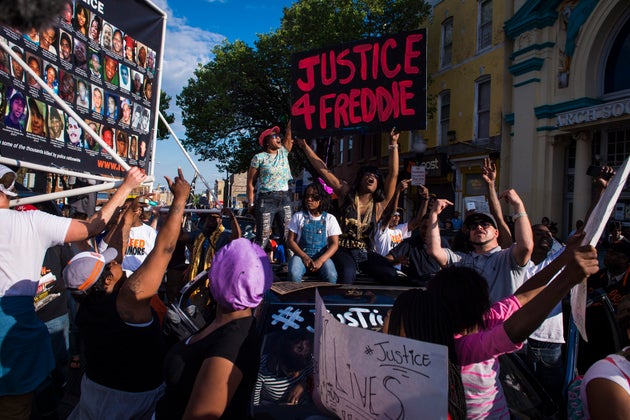 Protesters shout and chant while marching in solidarity with Freddie Gray after it was announced that...