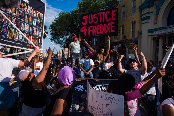 Protesters shout and chant while marching in solidarity with Freddie Gray after it was announced that criminal charges would be brought against the officers.