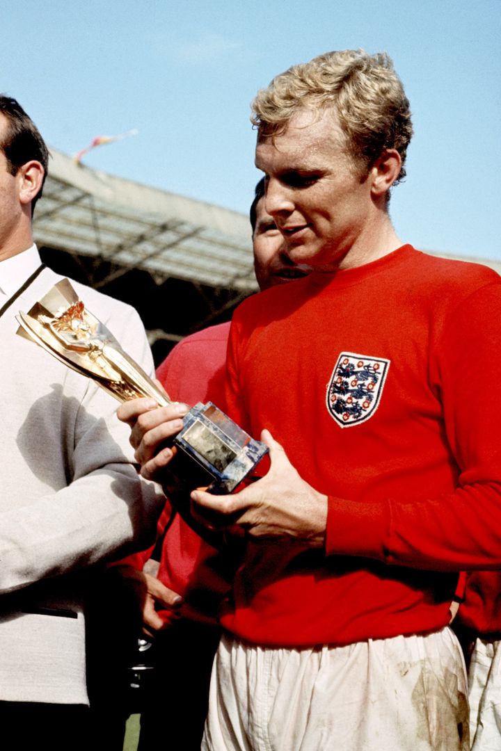 <strong>Bobby Moore has a close look at the Jules Rimet trophy after England won the 1966 World Cup</strong>