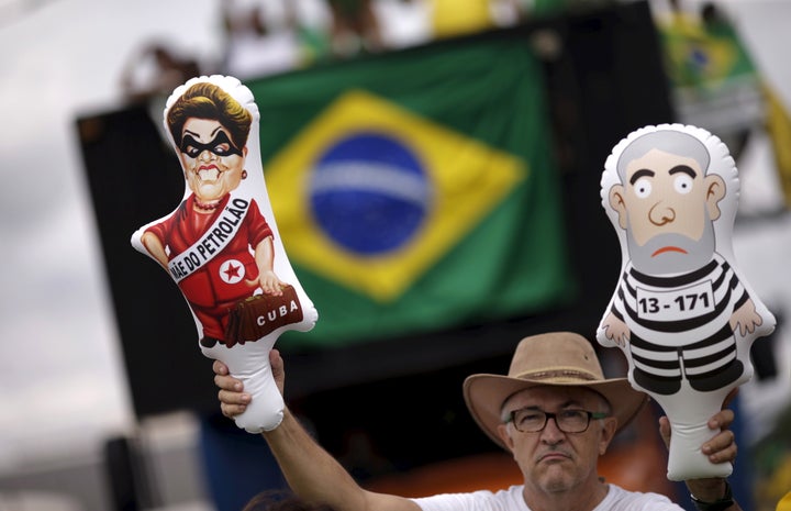 A demonstrator holds inflatable dolls depicting Brazil's former presidents Luiz Inacio Lula da Silva (R) and Dilma Rousseff at a December 2015 protest.