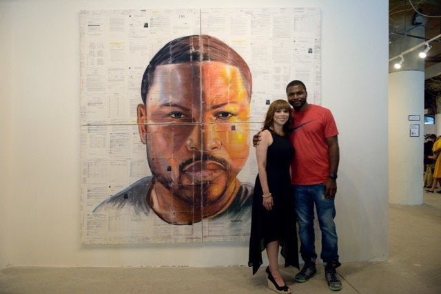 Russell Craig, who was in and out of the system for 12 years, stands beside actress Rosie Perez in front of his artwork displayed in Philadelphia during the Democratic National Convention.