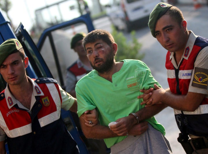 Turkish gendarmeries escort one of the 11 fugitive commandos who were involved in a bid to seize President Tayyip Erdogan dur