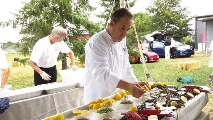 Chefs prepare hors d'oeuvres served outdoors