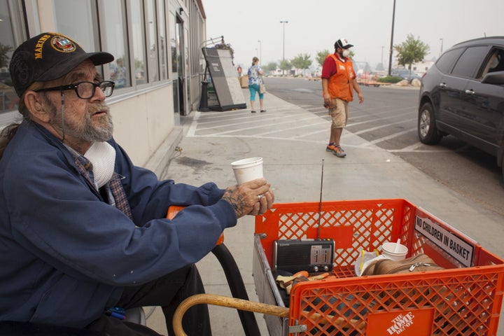 U.S. Marine Corps veteran Martin Silverhawk sits outside a Home Depot store, where he has been living since evacuating his home, during the Okanogan Complex fire in Omak, Washington August 25, 2015. In north-central Washington, a cluster of deadly fires dubbed the Okanogan Complex has burned more than 258,339 acres (104,546 hectares), overtaking last year's Carlton Complex fire as the state's largest on record. REUTERS/David Ryder