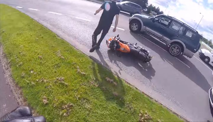 <strong>The motorist walks back to his vehicle after shoving the motorcyclist to the ground</strong>