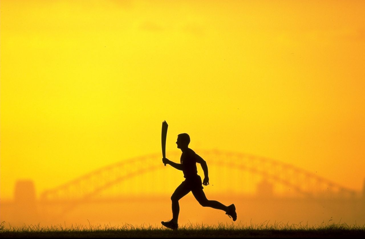 The 2000 Sydney Olympic Games Torch silhouetted against Sydney Harbour Bridge.