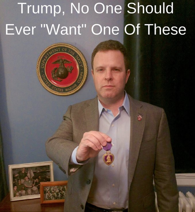 Democratic congressional candidate Sean Barney holds up his Purple Heart.