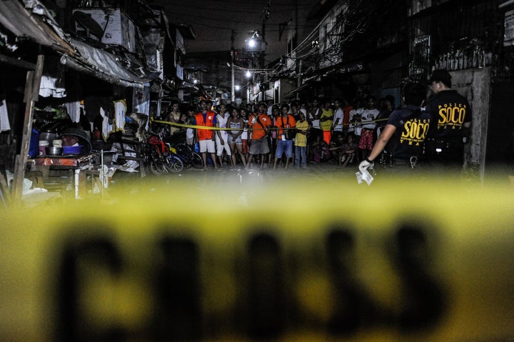 Police examine the body of an alleged drug dealer and victim of a summary execution on July 14 in Manila, Philippines.