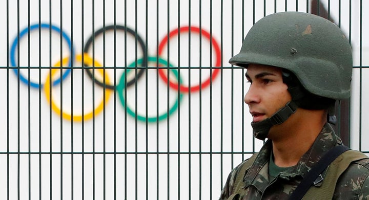 A Brazilian military police soldier patrols at the security fence outside the 2016 Rio Olympics Park in Rio de Janeiro, Brazil.