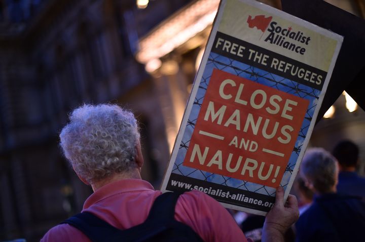 A participant holding a placard during a vigil in Sydney for an Iranian refugee who died after setting himself on fire on the Pacific island of Nauru.