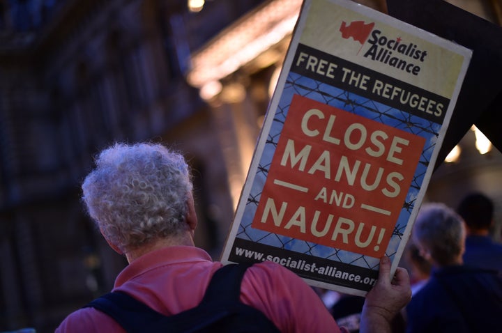 A participant holding a placard during a vigil in Sydney for an Iranian refugee who died after setting himself on fire on the Pacific island of Nauru.