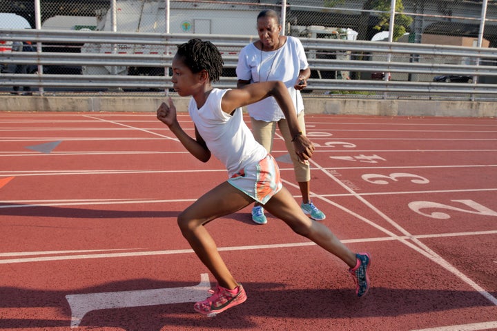 A coach times Rainn Sheppard during training at Boys and Girls High School, in the Brooklyn borough of New York.