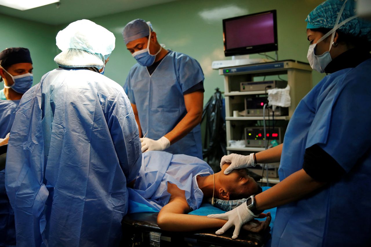 A patient lies on a bed during sterilization surgery in an operating room.