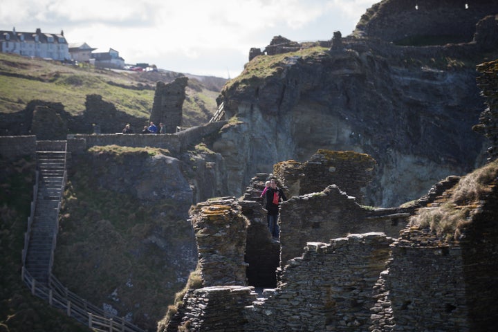 Tourists explore the ruins of Tintagel Castle. 