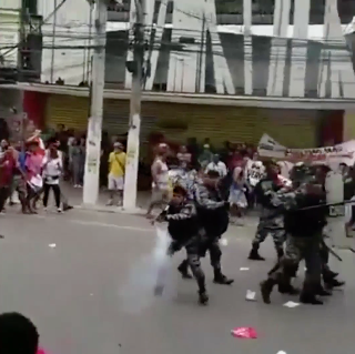 A cloud of smoke comes from the weapon as the officer fires