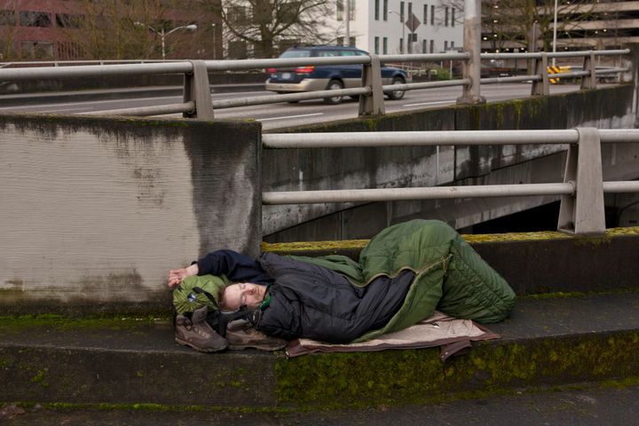 PORTLAND, OR - FEBRUARY 11: A homeless man sleeps on a downtown roadway overpass on February 11, 2012 in Portland, Oregon. Portland has embraced its national reputation as a city inhabited by weird, independent people, as underscored in the dark comedy IFC TV show 'Portlandia.' (Photo by George Rose/Getty Images)