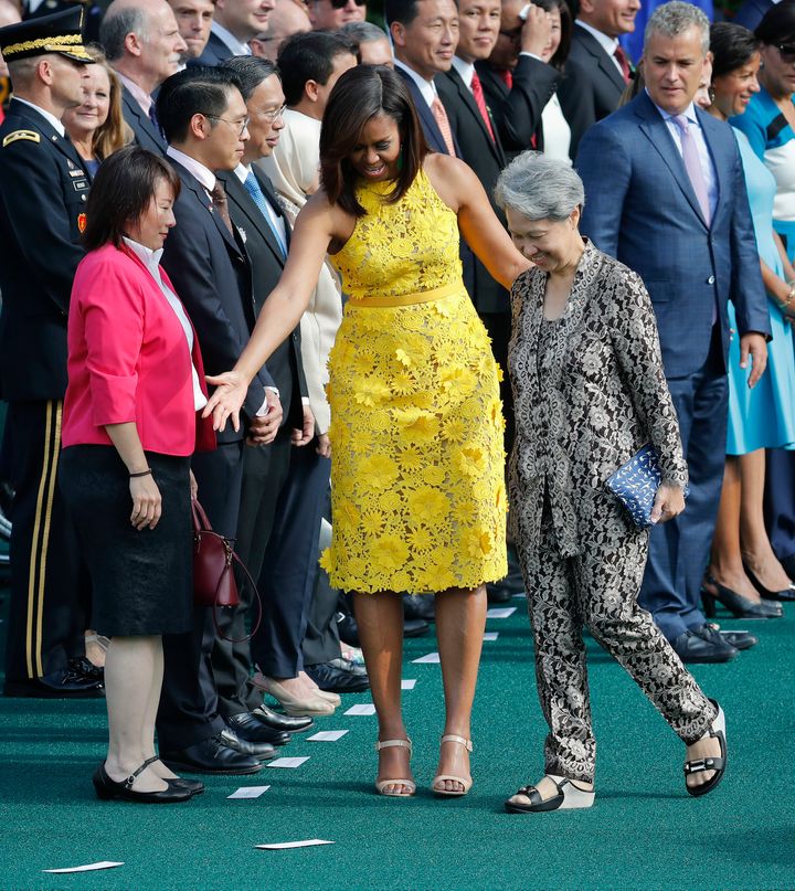 First lady Michelle Obama directs Ho Ching, right, wife of Singapore's Prime Minister Lee Hsien Loong, where to stand during a state arrival ceremony on the South Lawn of the White House in Washington, Tuesday, Aug. 2, 2016.