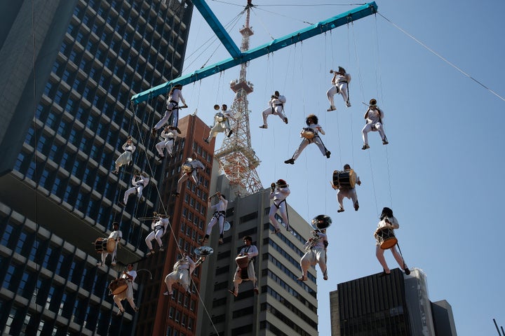 Musicians perform hanging from cables during the Olympic torch relay in Sao Paulo