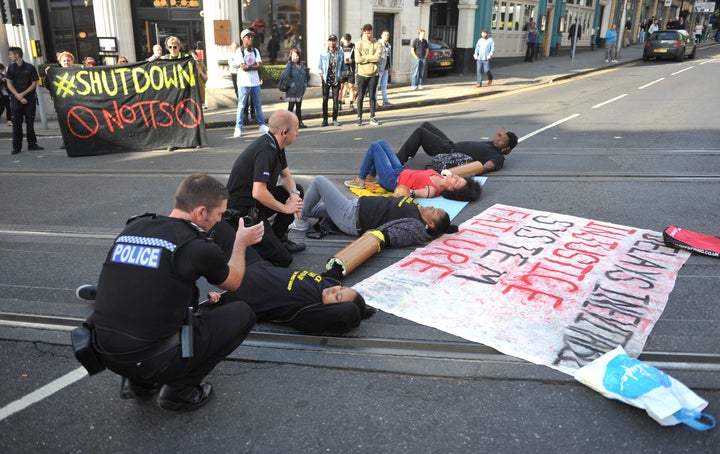<strong>Police officers talk with protesters in Nottingham city centre after activists blocked the tram tracks.</strong>