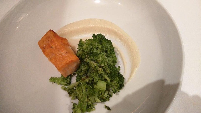 A salmon entree is served with broccoli and pureed cauliflower