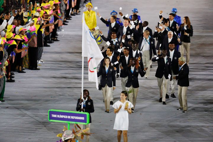 Flagbearer Rose Nathike Lokonyen (ROT) of the Refugee Olympic Athletes leads her contingent during the opening ceremony.
