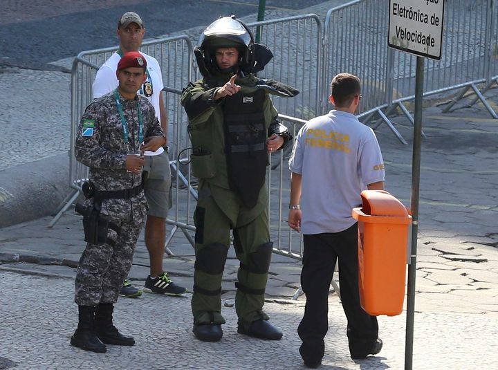 An agent of the bomb squad in protective clothing stands in the area near the finishing line of the men's cycling road race at the 2016 Rio Olympics after they made a controlled explosion, in Copacabana, Rio de Janeiro, Brazil August 6, 2016.