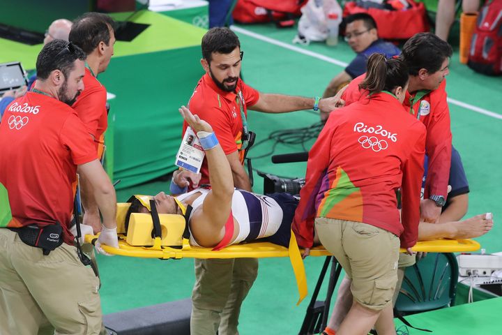 Said gestures to the crowd as he is stretchered away