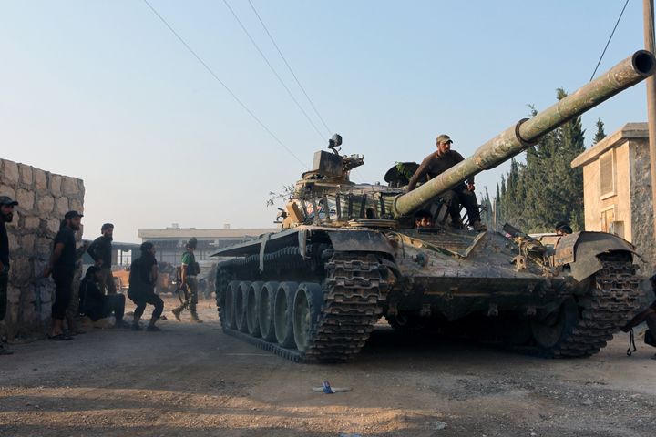 Rebel fighters ride a tank in an artillery academy of Aleppo, Syria, August 6, 2016.