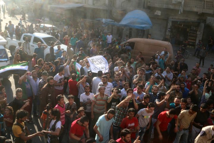 People carry a Free Syrian Army flag and a Jabhat Fatah al-Sham flag as they celebrate the news of the breaking of the siege of rebel-held areas of Aleppo, Syria August 6, 2016.