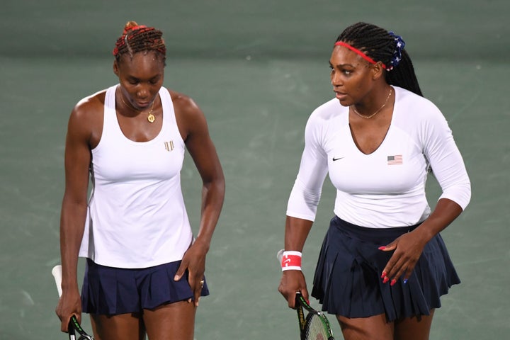 Serena Williams speaks to Venus Williams during their women's first round doubles tennis match against the Czech Republic's L