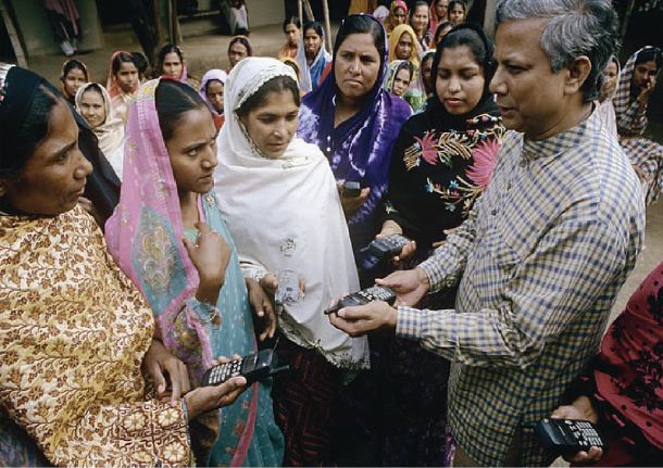 In his Magnum opus, Das Kapital (1867), Karl Marx states that the root cause of poverty is that the poor don't have access to a means of production. In this photo, Yunus provides a means of production (i.e., phone) to Grameen borrowers.