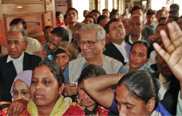 Yunus is flanked by lawyers and Grameen borrowers on the premises of the High Court on Thursday after he went to the court to file a writ challenging the legality of removing him from the Grameen Bank, which he founded in 1983.