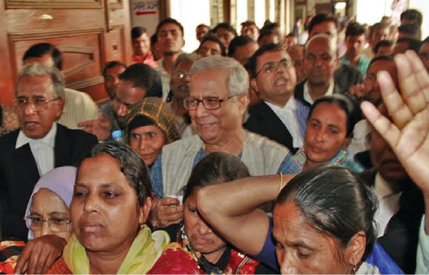 Yunus is flanked by lawyers and Grameen borrowers on the premises of the High Court on Thursday after he went to the court to