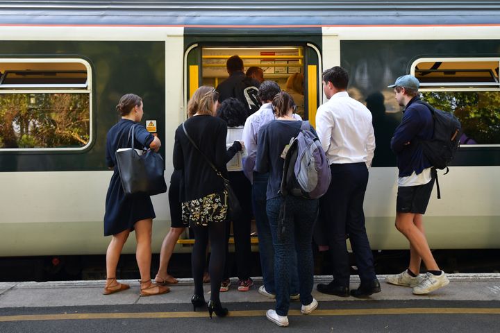 People line up to board a Southern rail service train at East Dulwich