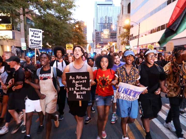 Protestors hold banners during a protest against police violence after Paul O'Neal, an unarmed 18-year-old man, was shot by C