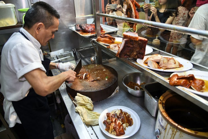 Chan Hon Meng chopping braised chicken at his Hong Kong Soya Sauce Chicken Rice and Noodle stall in Singapore.