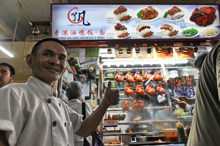 Singaporean chef Chan Hon Meng poses infront of his Hong Kong Soya Sauce Chicken Rice and Noodle stall in Singapore on July 22, 2016.
