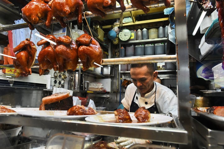 Singaporean chef Chan Hon Meng prepares meals for customers at his Hong Kong Soya Sauce Chicken Rice and Noodle stall.