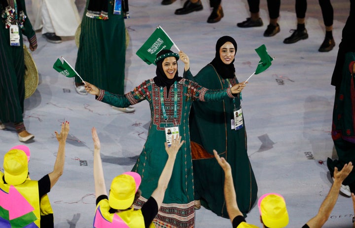 Sarah Attar (KSA) of Saudi Arabia waves flags during the opening ceremony.