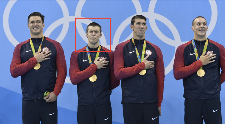 Nathan Adrian, Ryan Held, Michael Phelps and Caeleb Dressel listen to the U.S. national anthem as they stand on the podium of the men's 4x100m freestyle relay final.